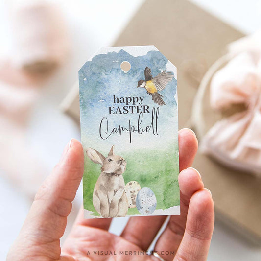 hand holding happy easter gift tag with bunny and bird design