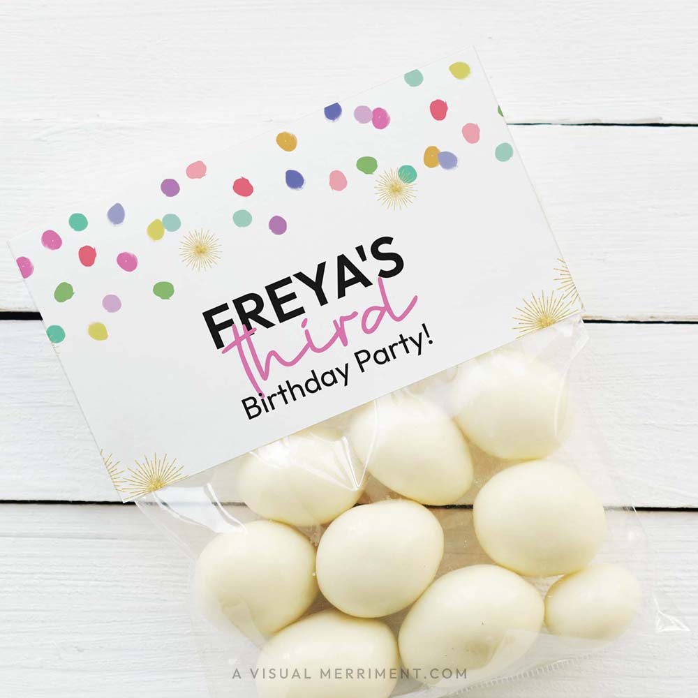 bag of white candy on timber background with rainbow confetti printable bag topper template