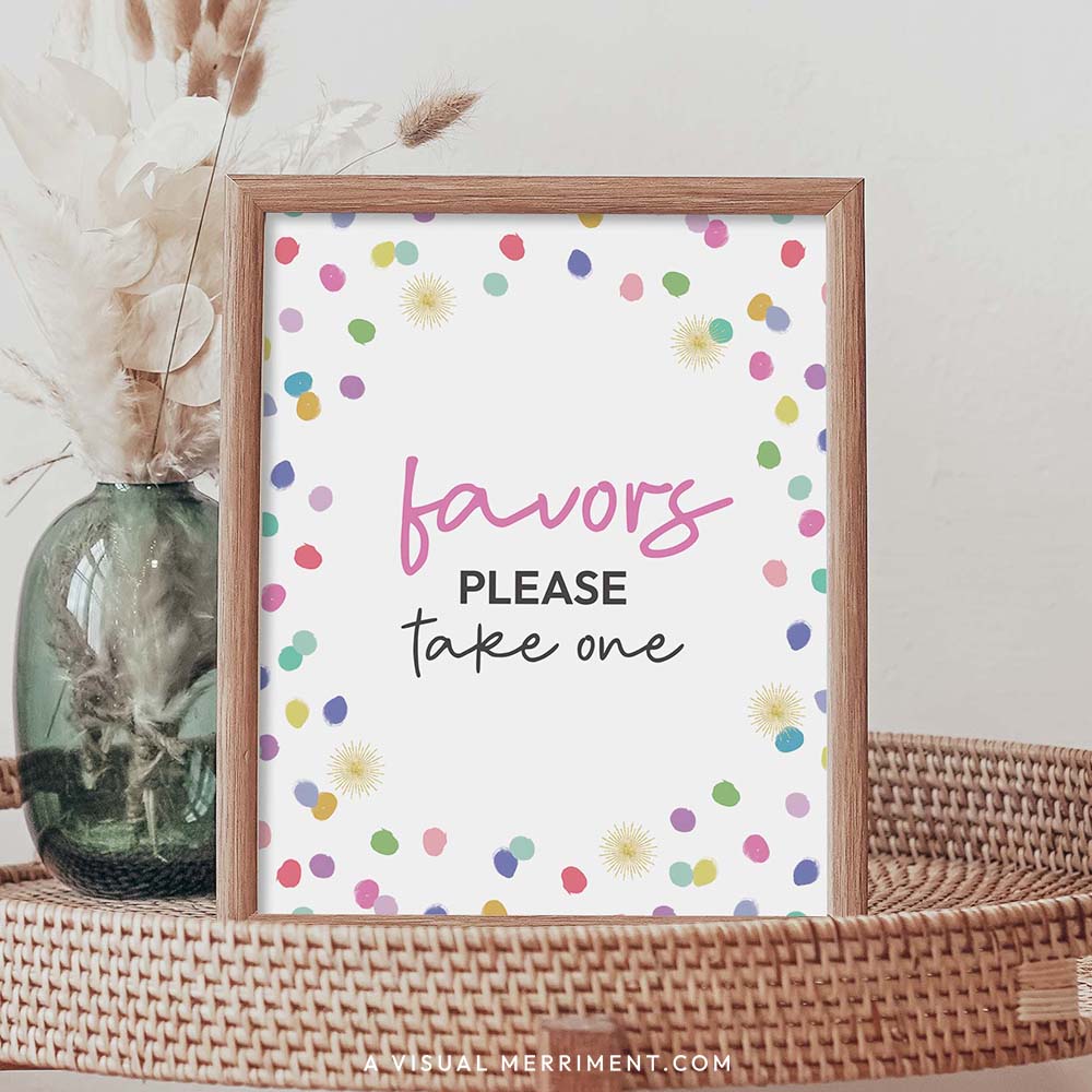 Favors please take one rainbow confetti polka dot printable party sign in a frame sitting on a grass table with a vase of boho stems