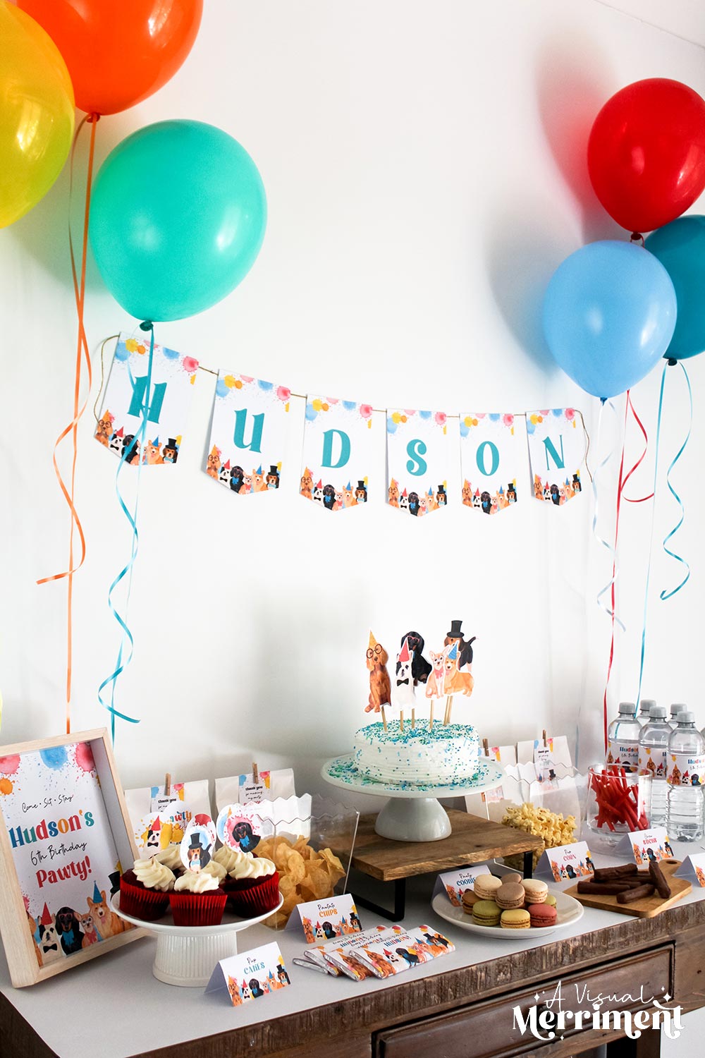 Dog party birthday party setup with balloons, cake, and decorations on a table