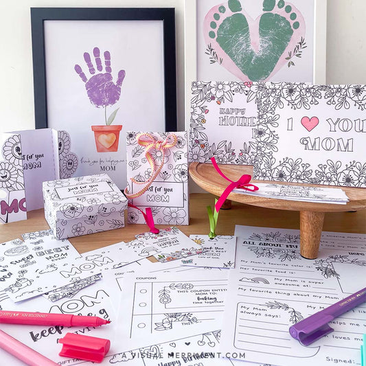 printed gifts for mom, including cards, coloring pages, and markers on a wooden surface.