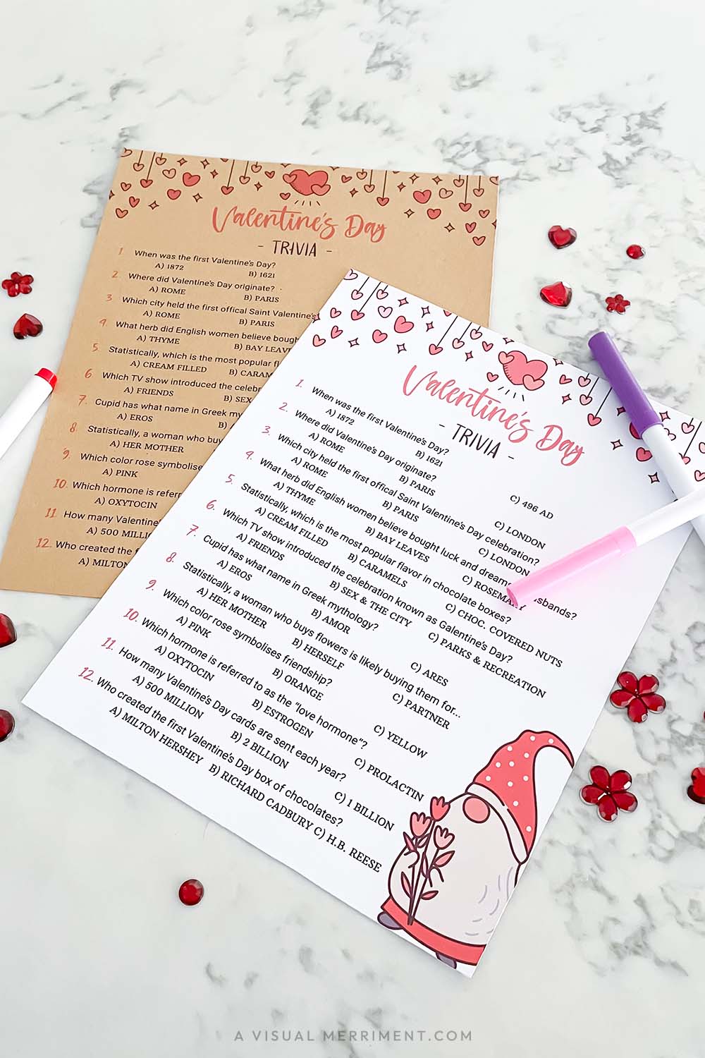Two Valentine's Day trivia pages with markers and sequins on a marble surface.