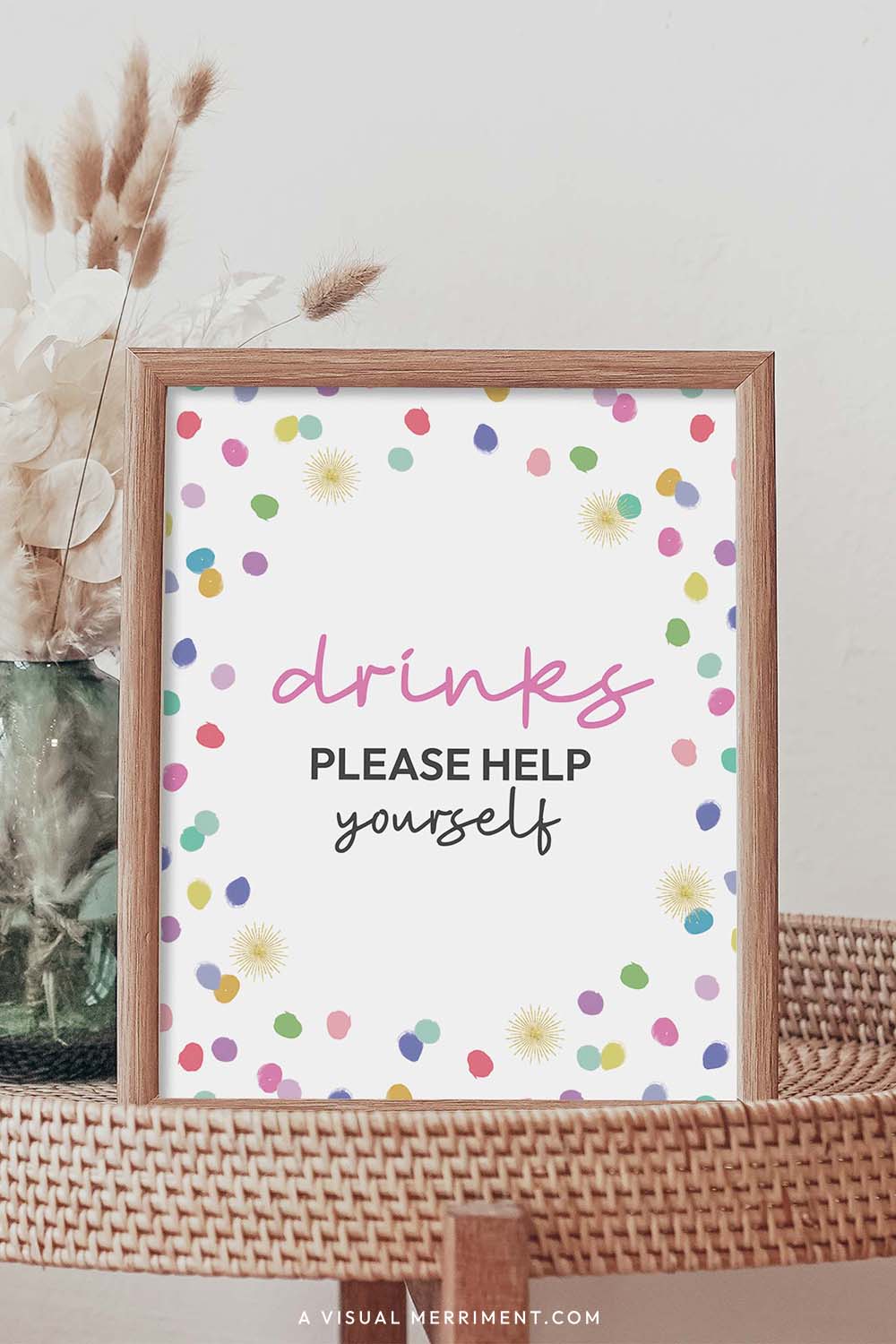 Drinks please help yourself rainbow confetti polka dot printable party sign in a frame sitting on a grass table with a vase of boho stems