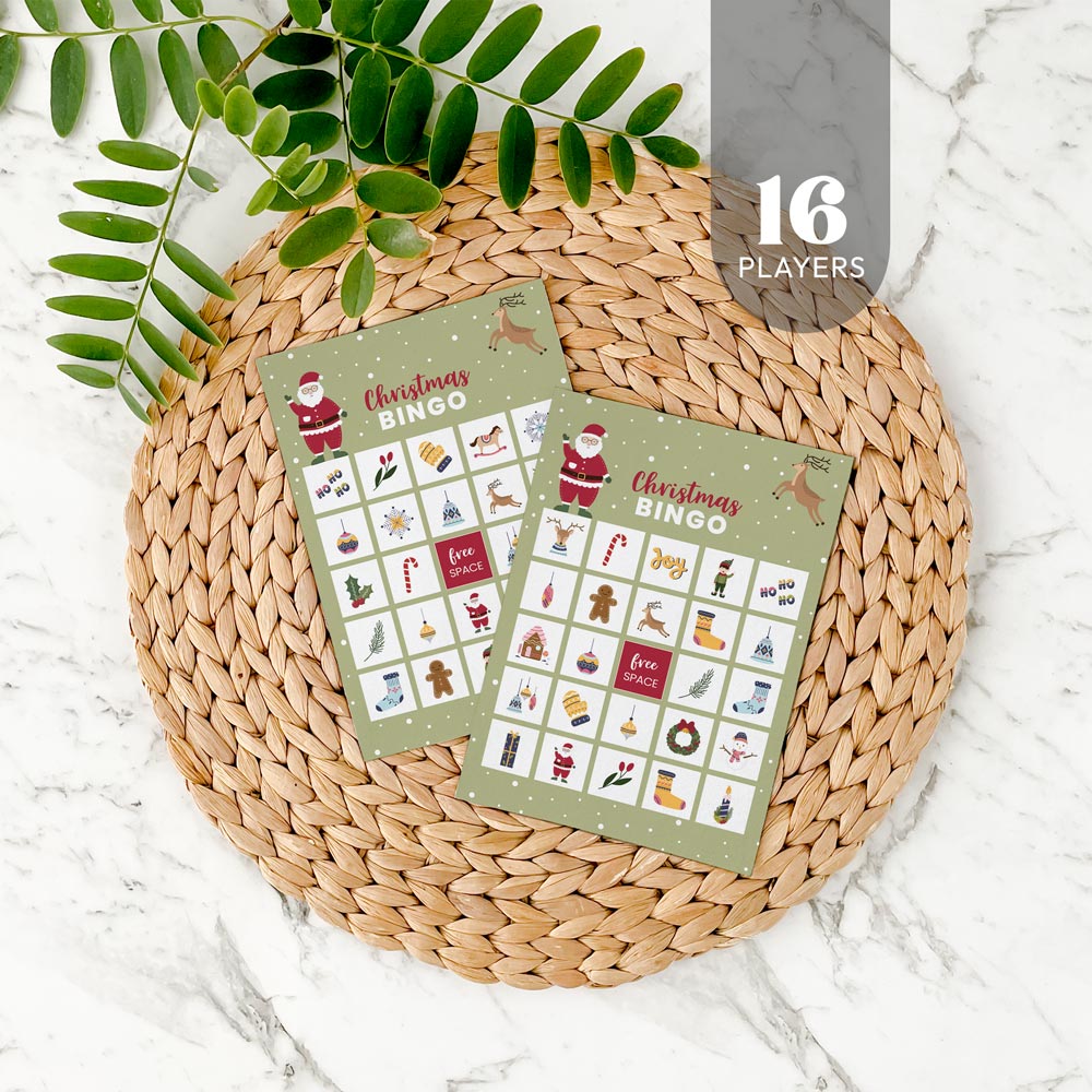Two Christmas bingo cards for 16 players on a woven mat with decorative leaves.