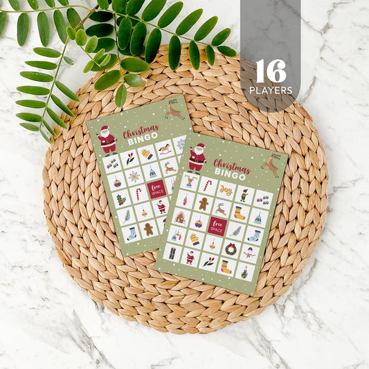 Two Christmas bingo cards for 16 players on a woven mat with decorative leaves.