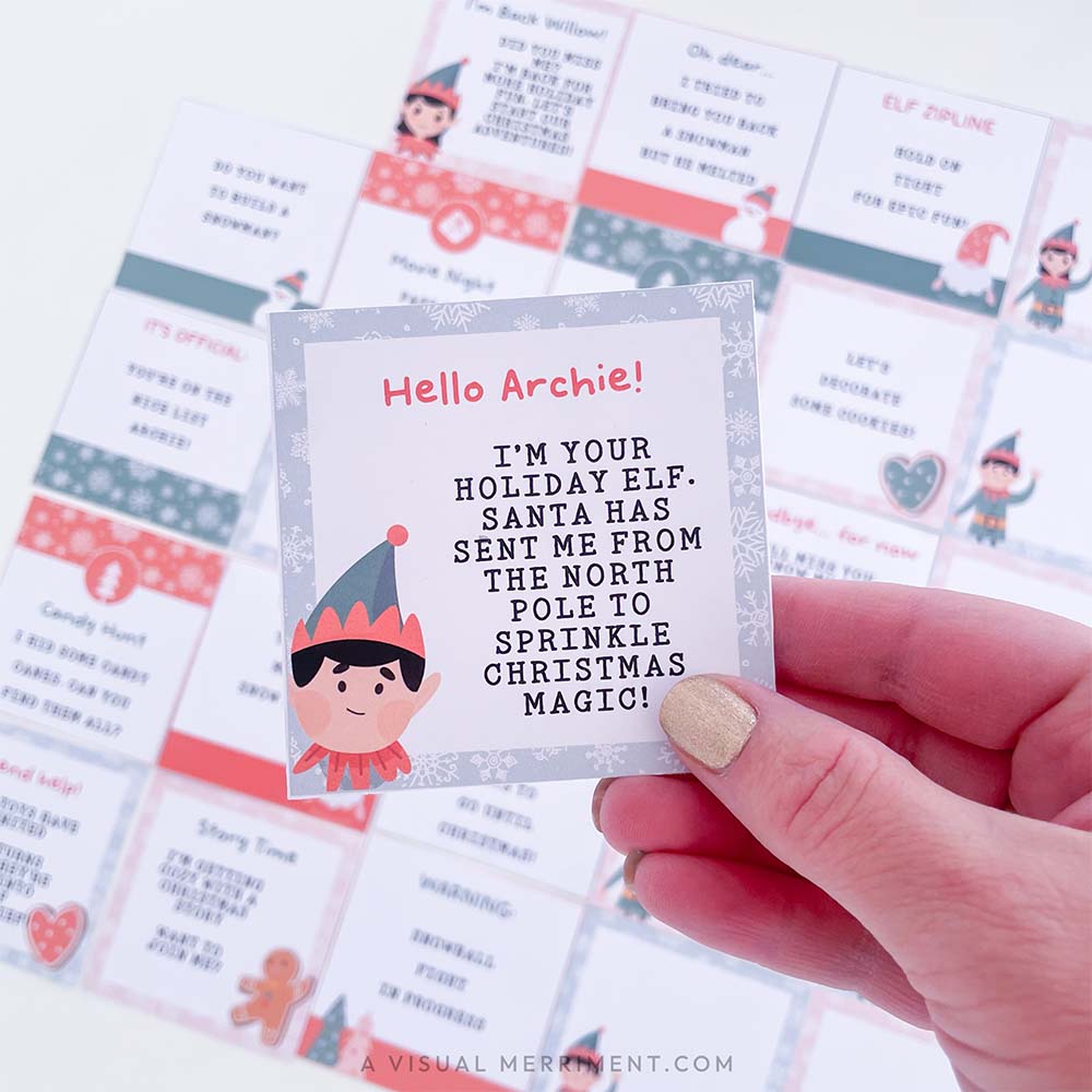 hand holding elf on the shelf arrival note with other christmas elf notes in background