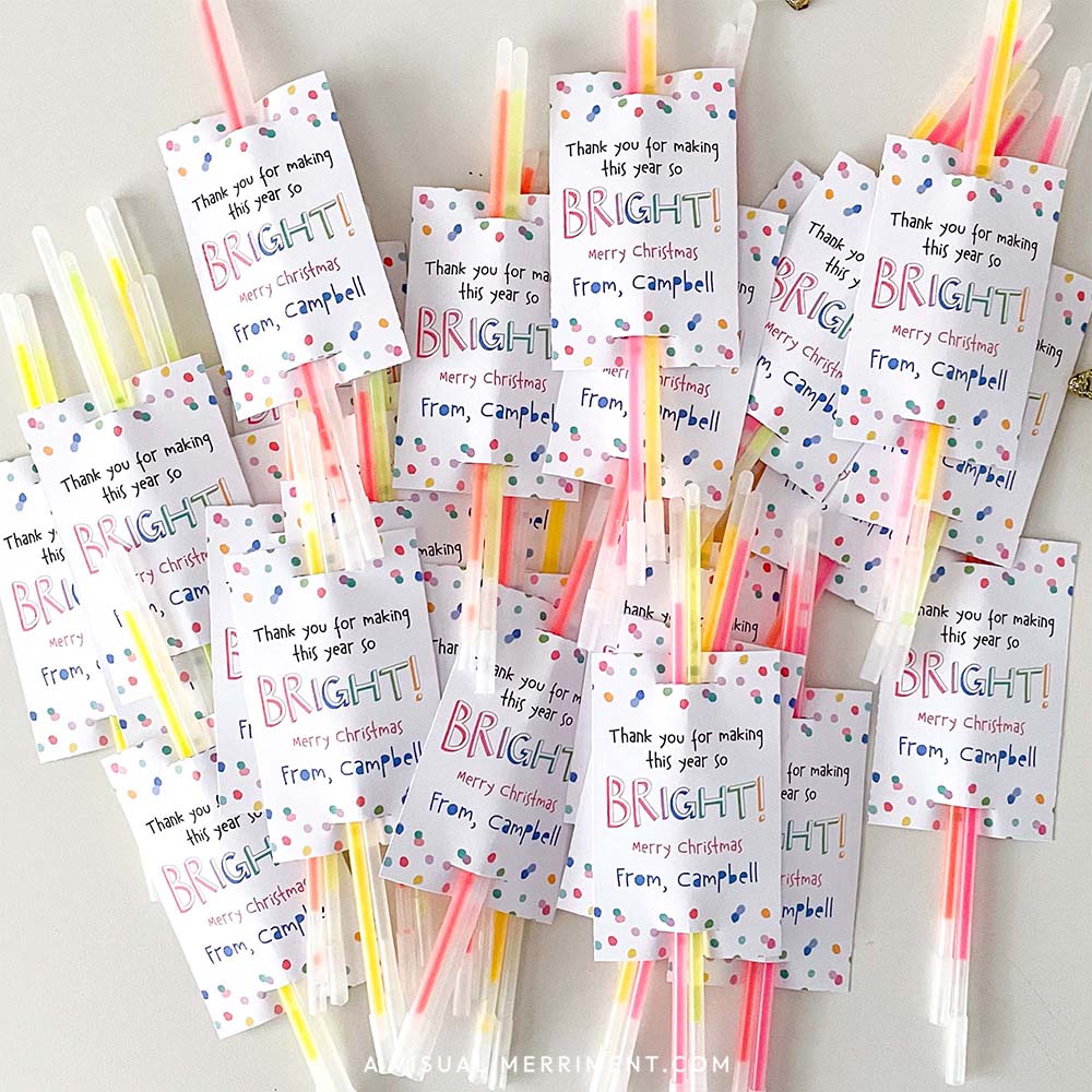 pile of made merry christmas glow stick holder tags with glow sticks inserted