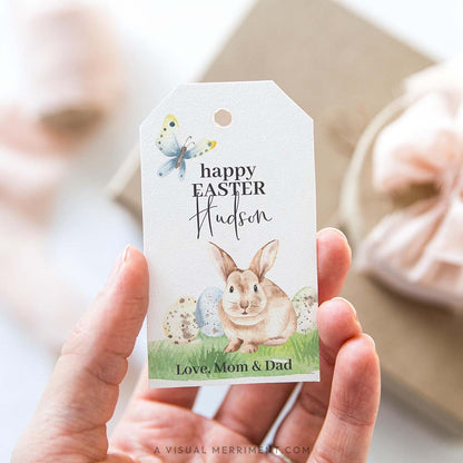 hand holding happy easter gift tag with bunny and butterfly design