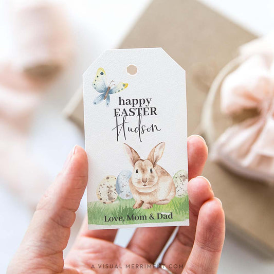 hand holding happy easter gift tag with bunny and butterfly design