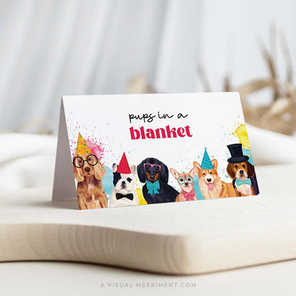 Party dogs with hats and paint splatters ‘pups in a blanket’ text printable place cards template on board