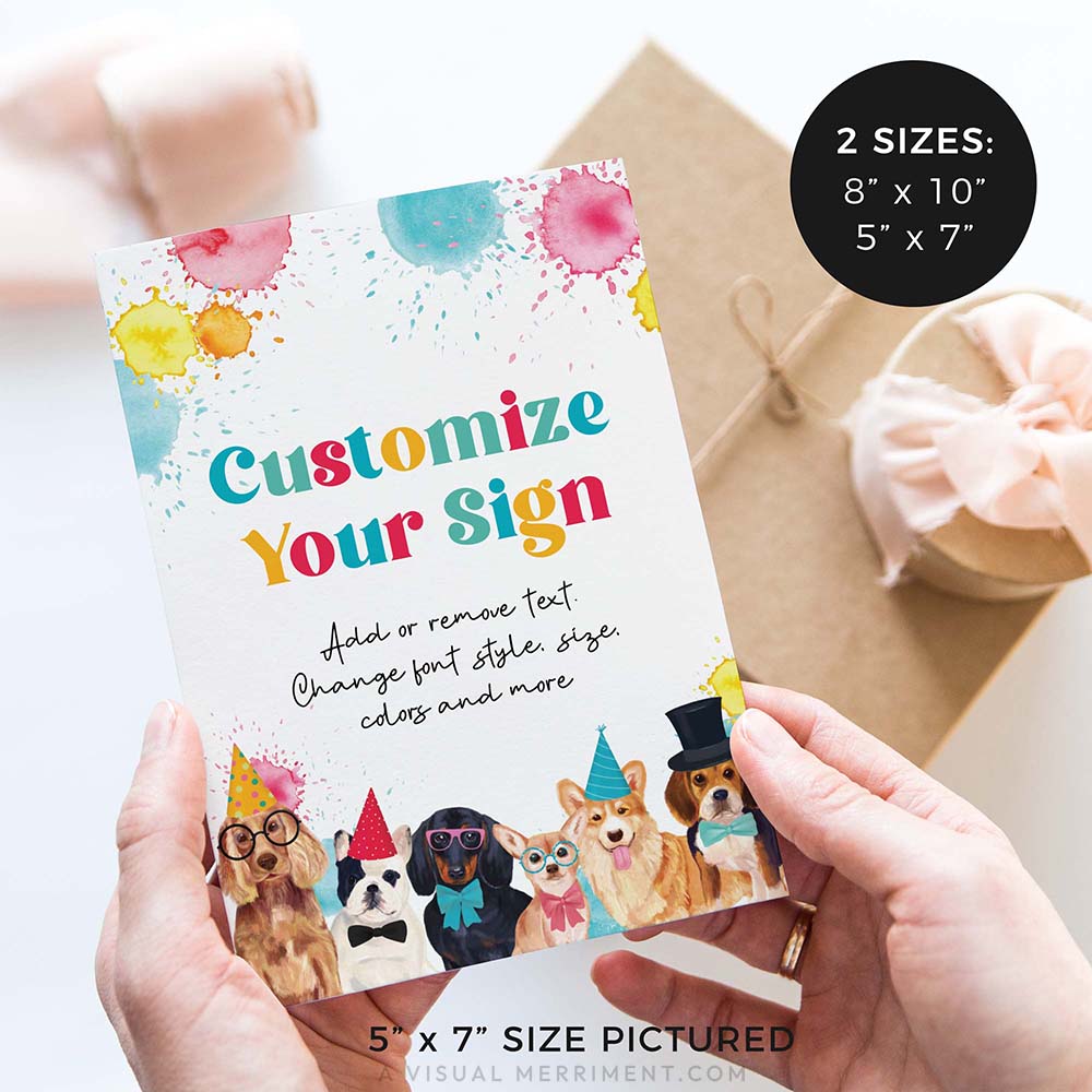 hands holding birthday party sign with dogs wearing party hats and gifts in background