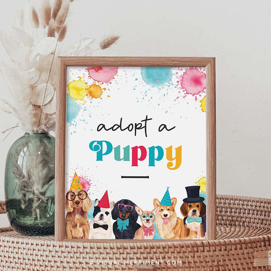 adopt a puppy dog printable party sign in a frame sitting on a grass table with a vase of boho stems
