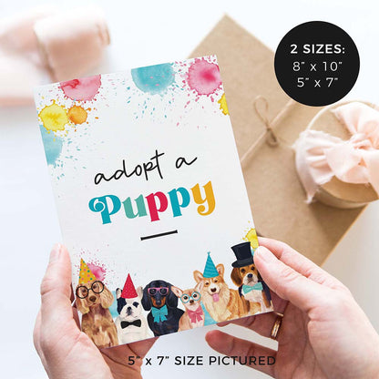 hands holding adopt a puppy birthday party sign with party dogs and gifts in background