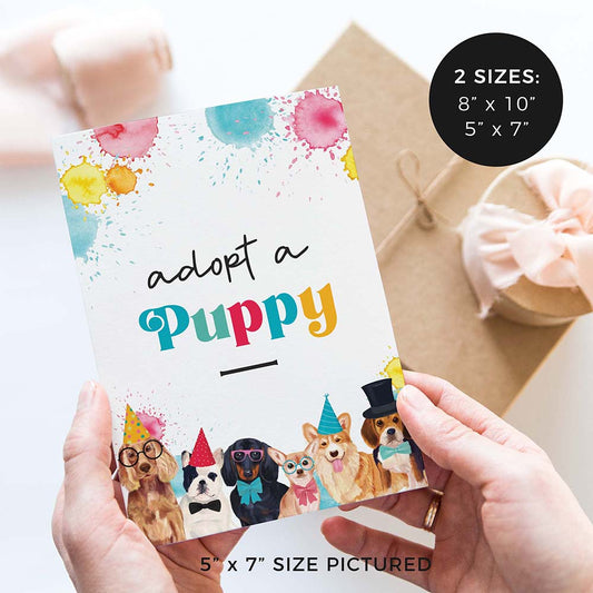hands holding adopt a puppy birthday party sign with party dogs and gifts in background