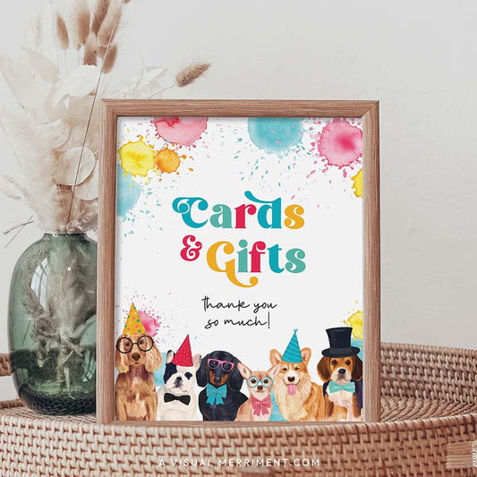 Cards and gifts dog printable party sign in a frame sitting on a grass table with a vase of boho stems