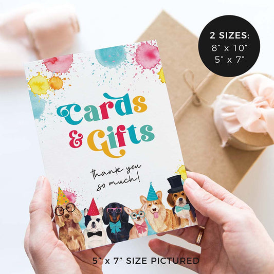hands holding cards and gifts birthday party sign with party dogs and gifts in background
