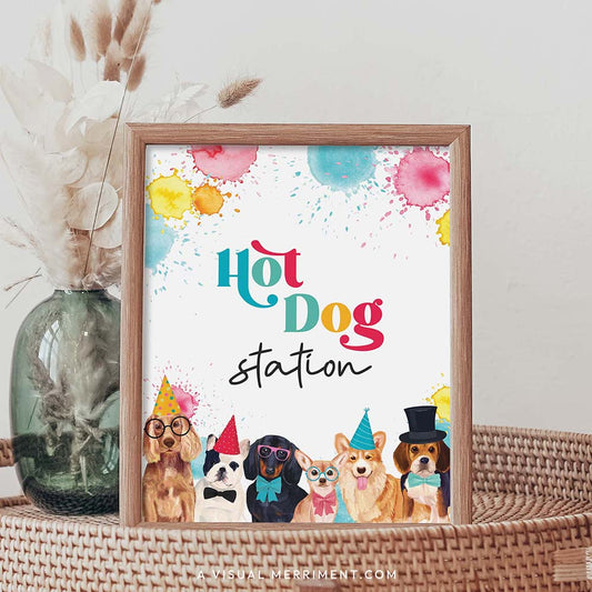 Hot dog station party dog printable party sign in a frame sitting on a grass table with a vase of boho stems