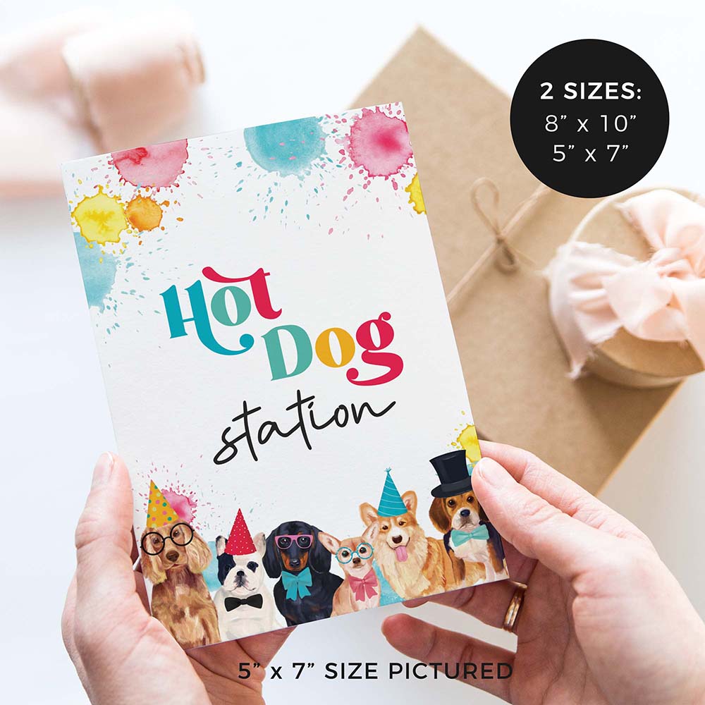 hands holding Hot dog station party sign with party dogs and gifts in background