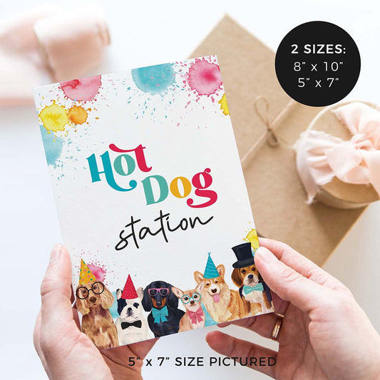 hands holding Hot dog station party sign with party dogs and gifts in background