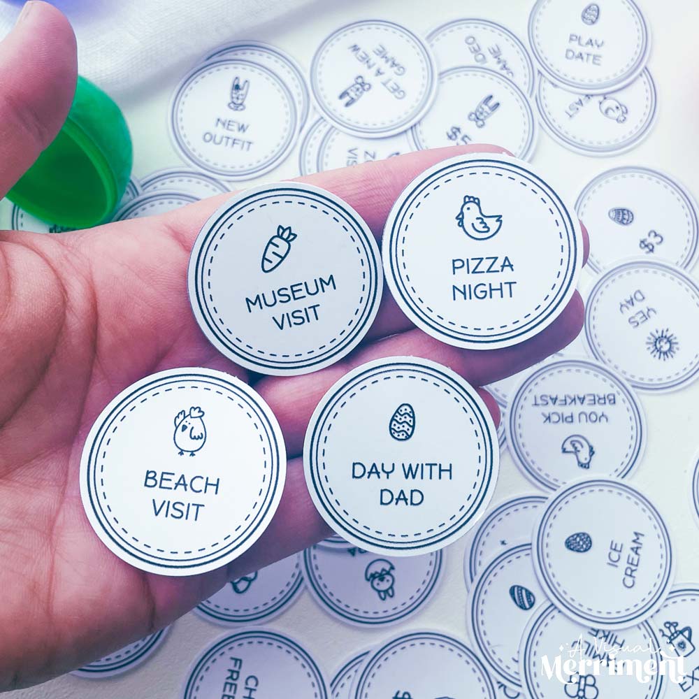 hand holding several non candy black and white printed rewards easter egg tokens