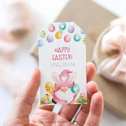 Hand holding a personalized Easter gift tag with a colorful pink gnome design
