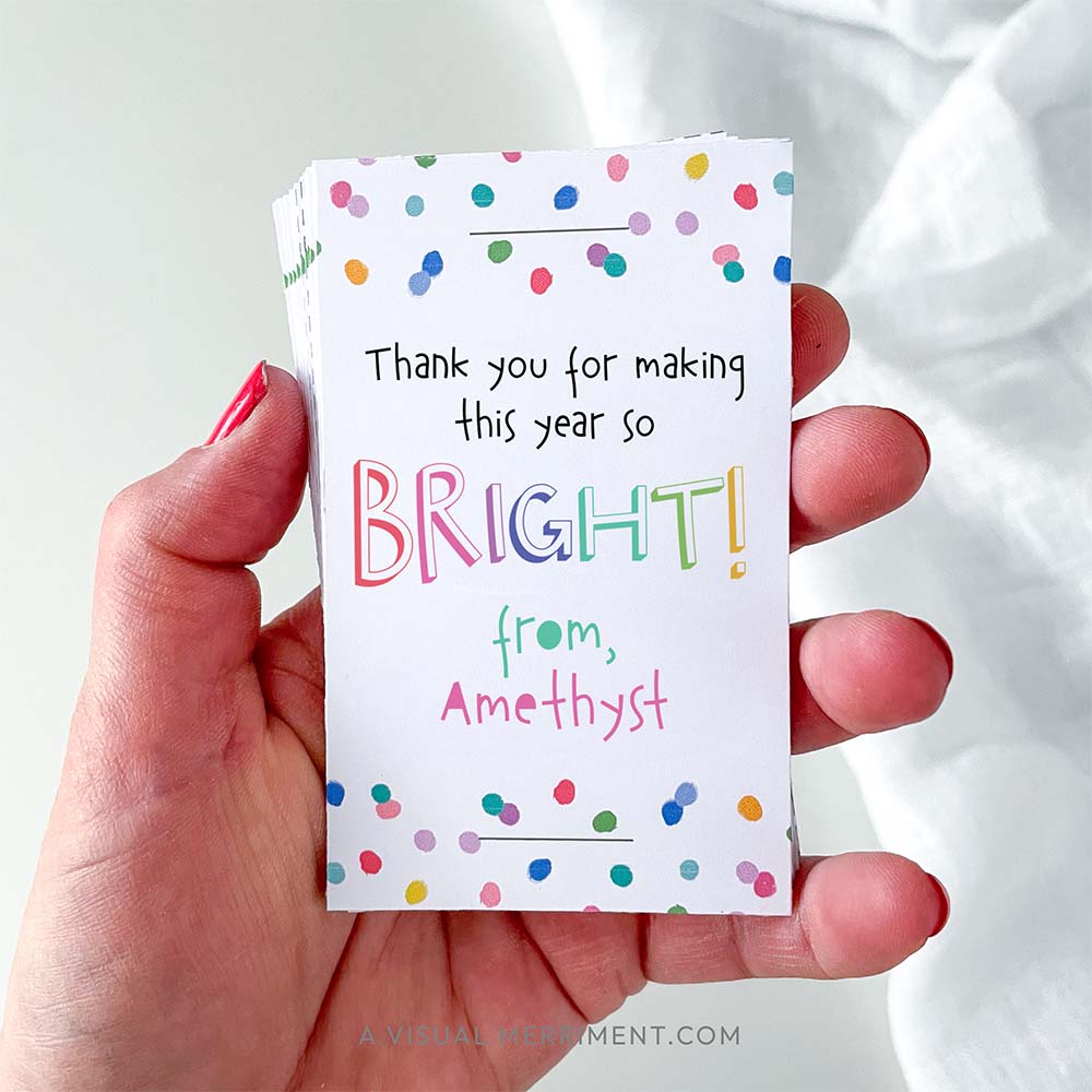 Hand holding pack of cards that say 'thank you for making this year bright' in colorful rainbow confetti polka dot design