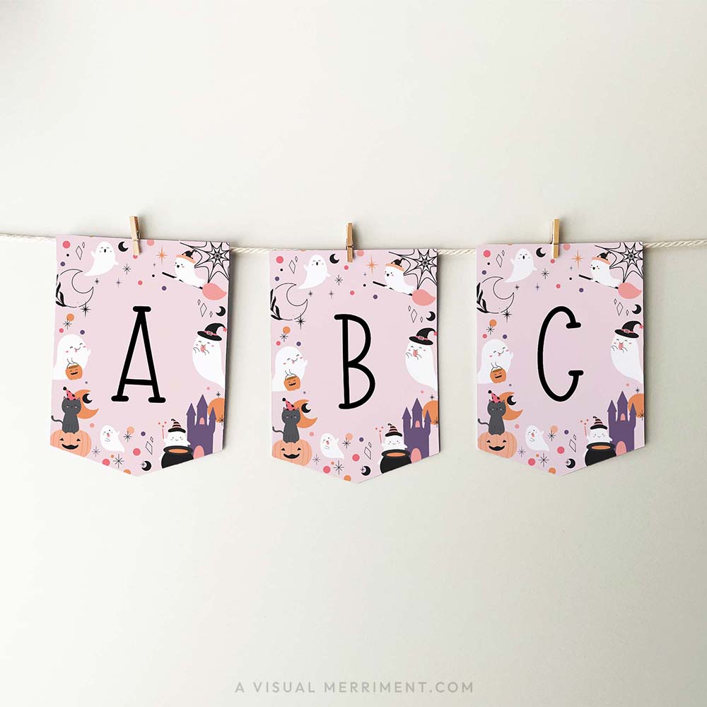 pink halloween banner with ghosts, cats and celestial elements. has letters a, b, c with banner strung with pegs on rope