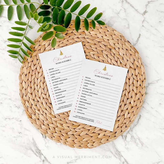 2 modern christmas word scramble cards on a woven placemat with green leaves
