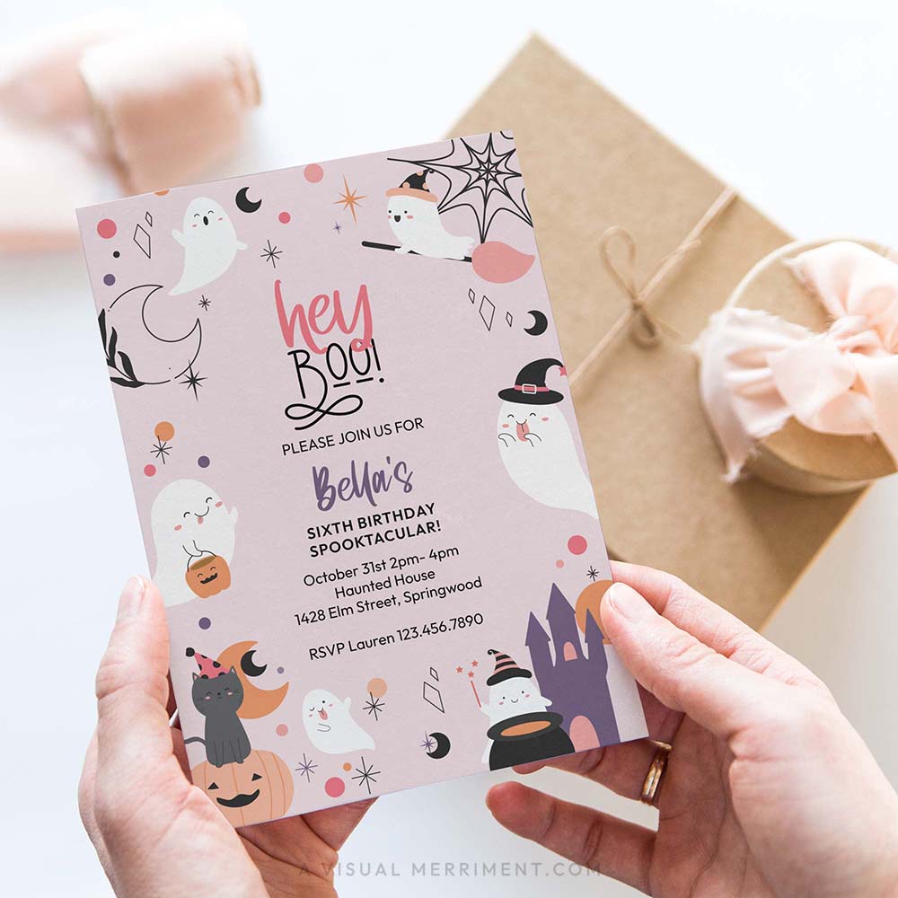 hand holding hey boo printable pink ghost Halloween party invitation with ghosts, cat, castle, stars and pumpkins