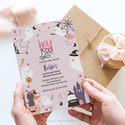 hand holding hey boo printable pink ghost Halloween party invitation with ghosts, cat, castle, stars and pumpkins