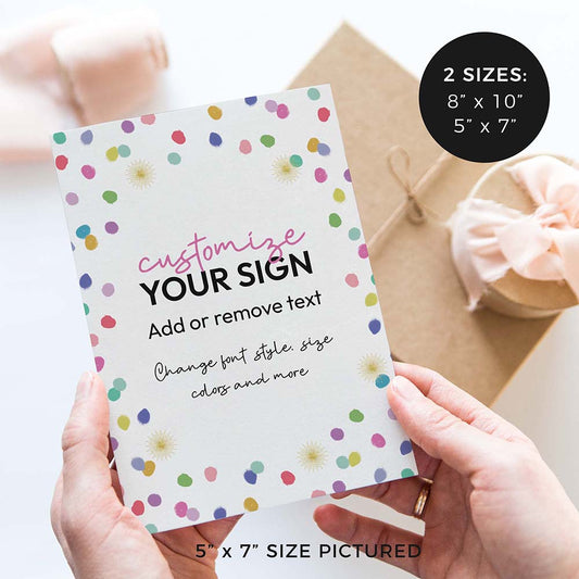 hands holding birthday party sign with colorful rainbow confetti polka dots and gifts in background