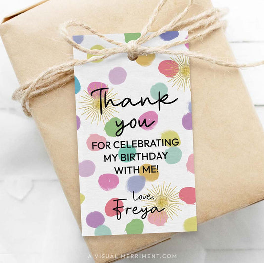 Gift wrapped in brown paper with a colorful 'thank you' tag featuring colorful rainbow confetti polka dots