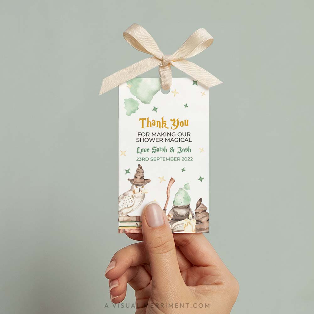 Hand holding baby shower printable gift tag with magic wizard school design in a harry potter style