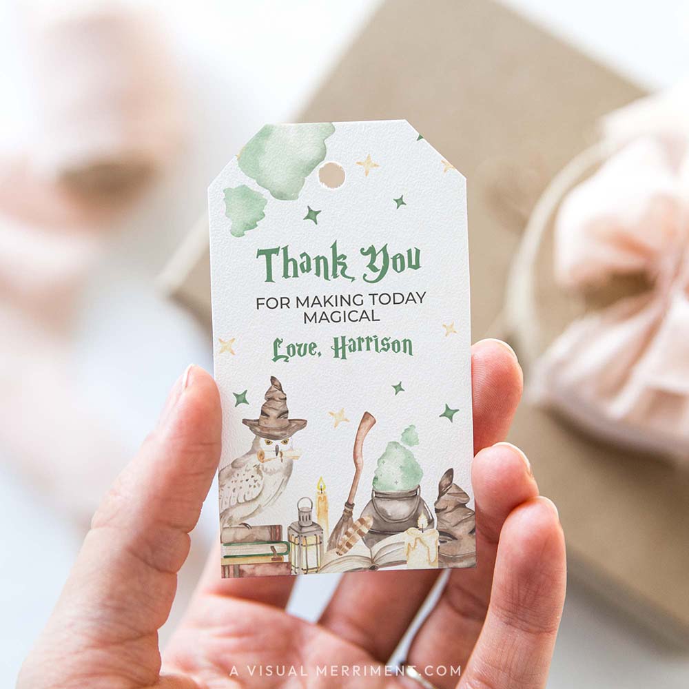 Hand holding printable gift tag with magic wizard school design in a harry potter style