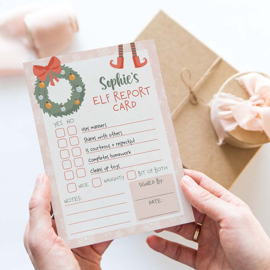 hands holding pink naughty or nice report card from girl elf on the shelf