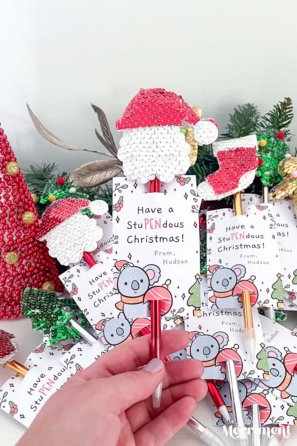hand holding santa pen gift with a printed koala gift tag