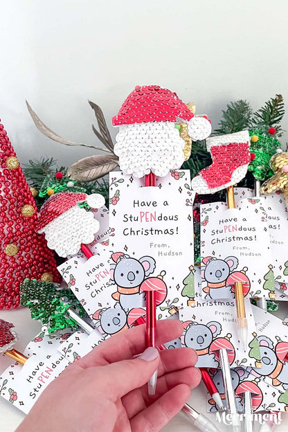 hand holding santa pen gift with a printed koala gift tag
