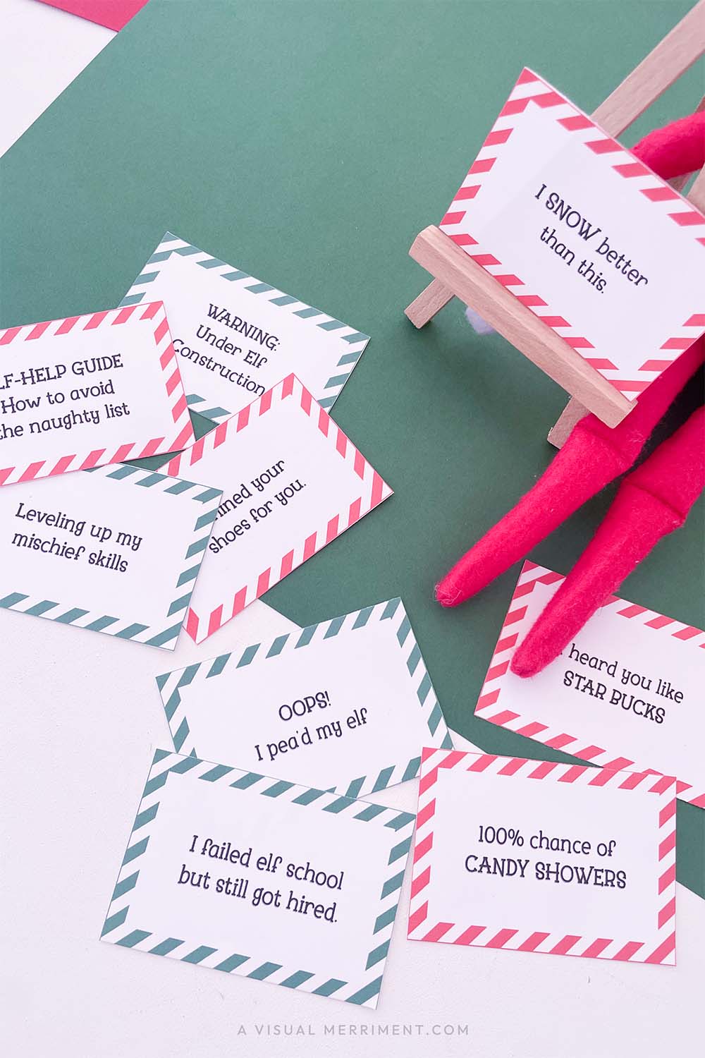 Vertical of red and green funny elf on the shelf ideas signs on easel next to elf doll