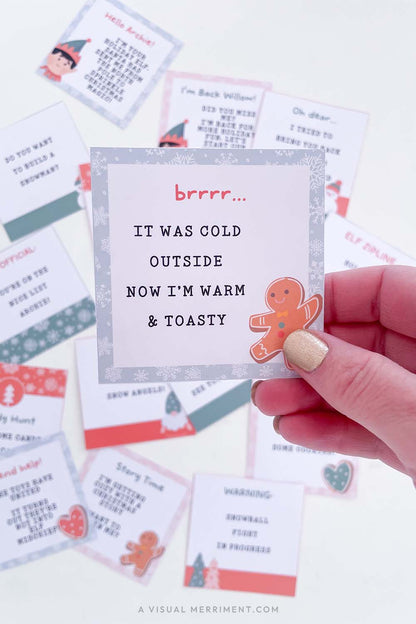 hand holding elf on the shelf note with other christmas elf notes in background