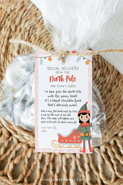 vertical pink elf on the shelf hot chocolate instructions gift tag tied to bag of candy treats