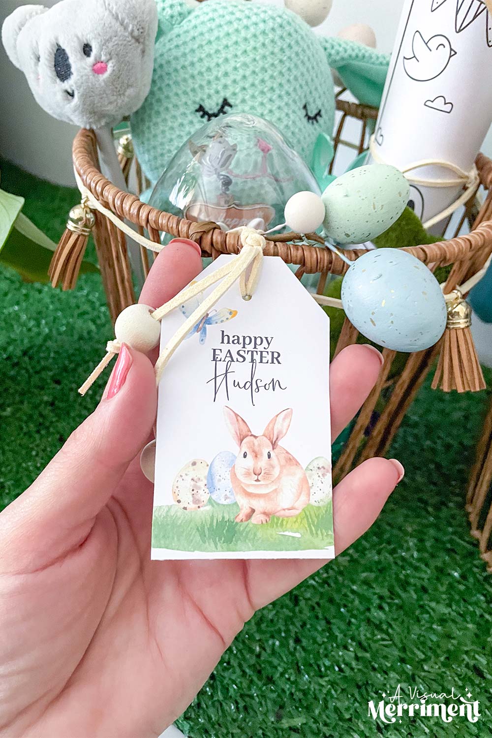 hand holding happy easter gift tag on Easter basket in bunny and butterfly design