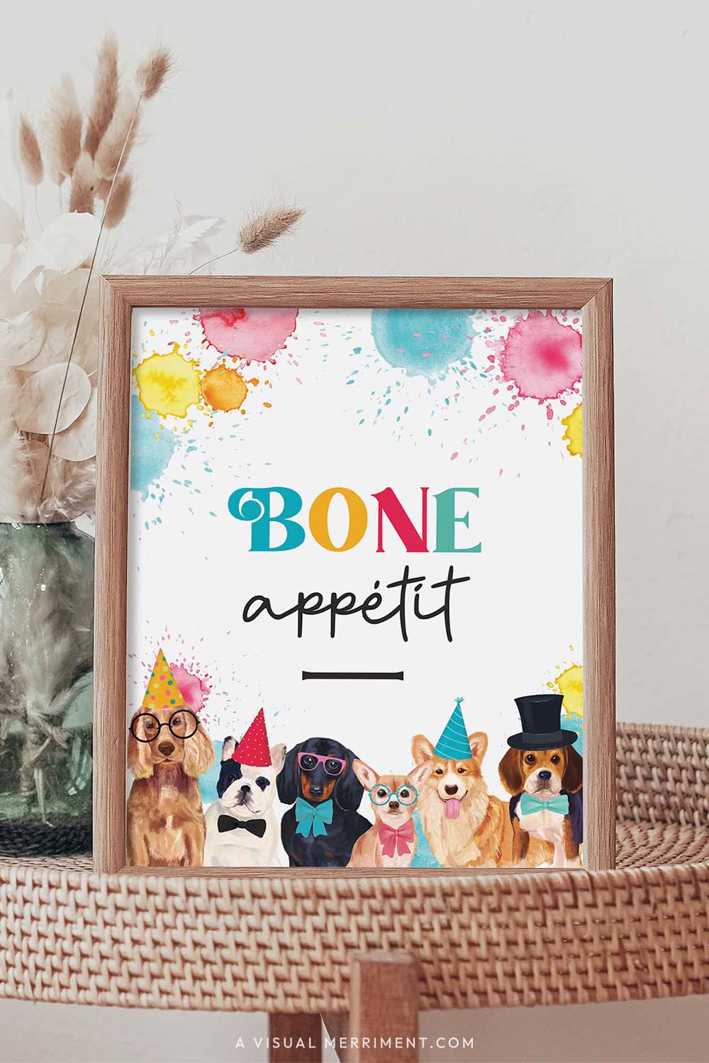Bone appetit dog printable party sign in a frame sitting on a grass table with a vase of boho stems