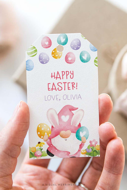 vertical of Hand holding a personalized Easter gift tag with a colorful pink gnome design