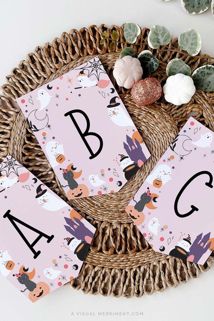 vertical of pink halloween banner in celestial design sitting on jute mat with pumpkin props