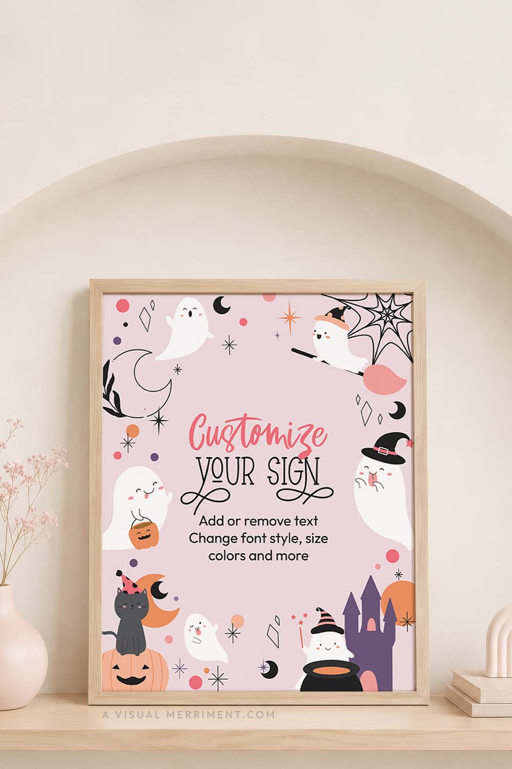 vertical of printable pink ghost halloween sign sits in frame on timber shelf with soft pink accessories