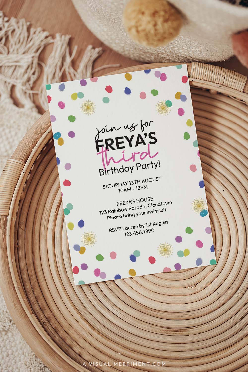 vertical of colorful rainbow confetti printed invitation template sitting on a boho style table