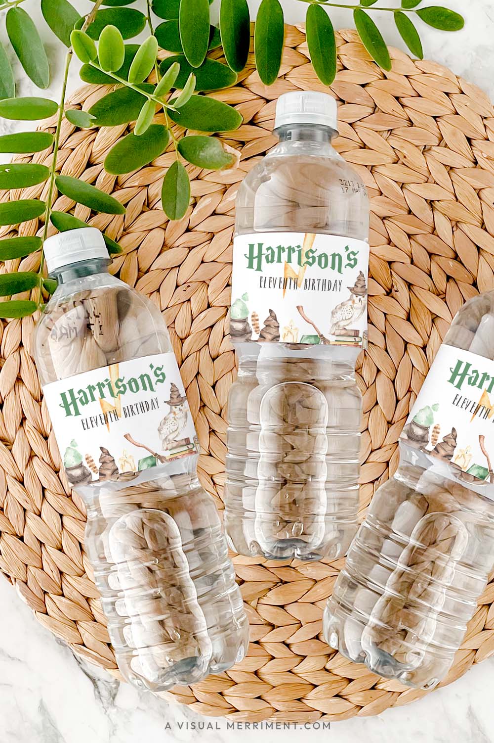 Vertical of bottles with harry potter style water bottle labels in magical elements on grass mat with leaves